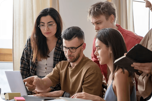 Group of learners collaborating around a laptop.
